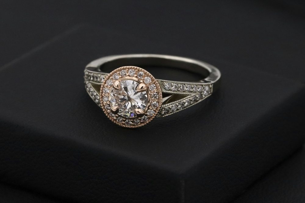 Halo engagement ring resting on black velvet